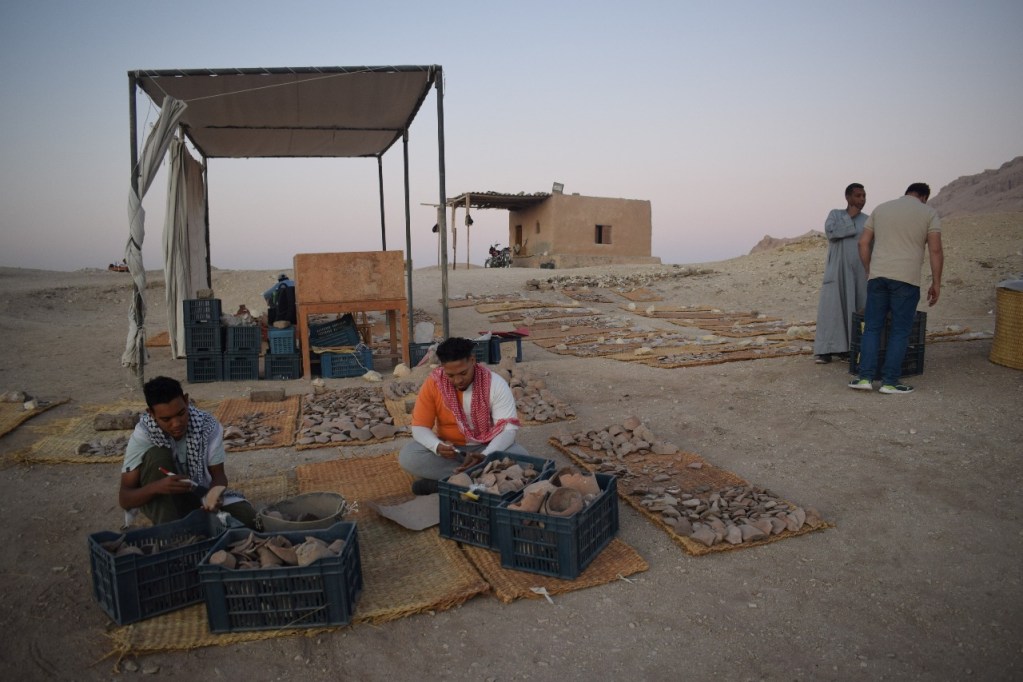 El ceramista Mahmoud El-Shafei selecciona piezas junto a los obreros en la zona del yacimiento habilitada para la cerámica.